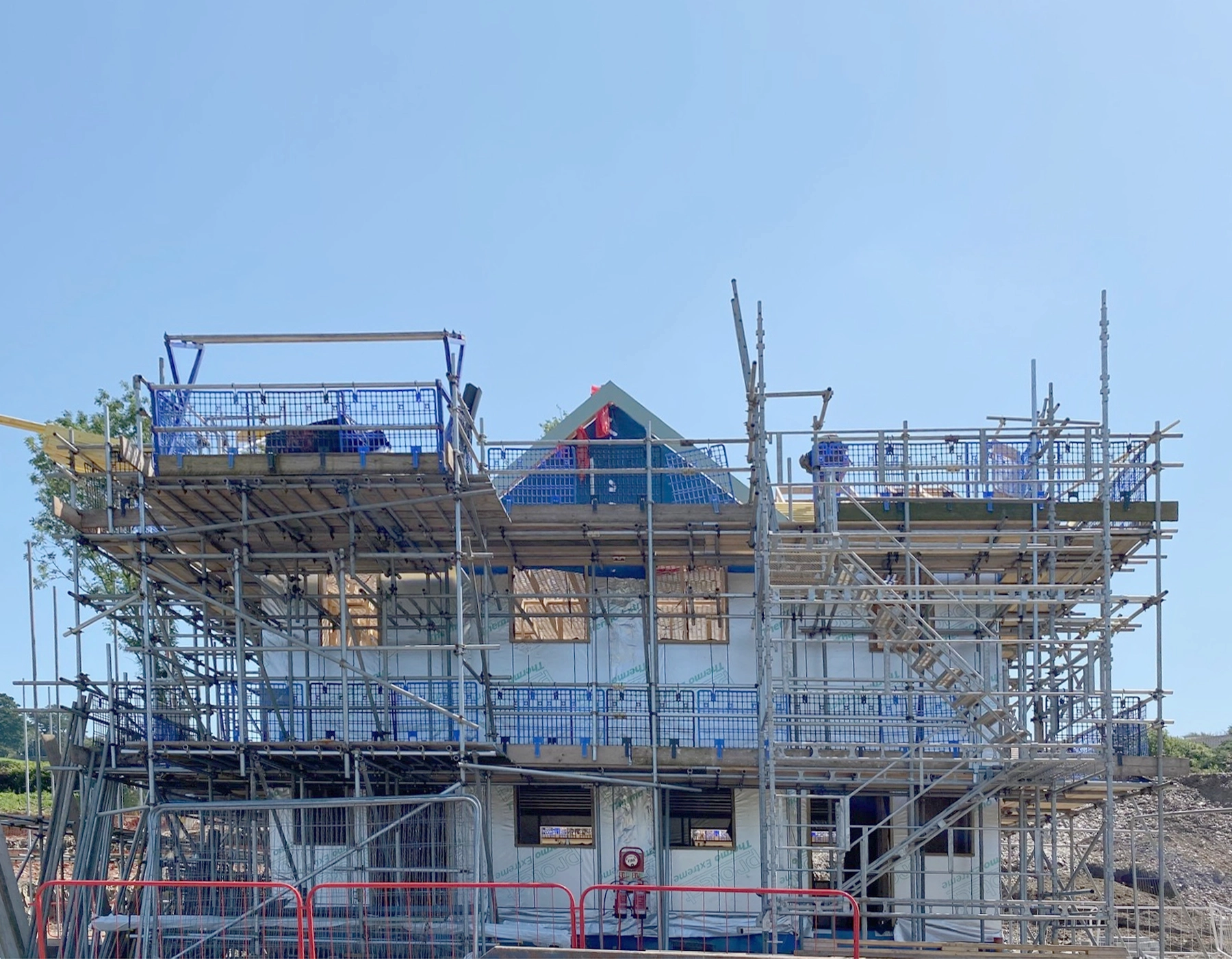 Building work in progress at the Bicclescombe site. A phiotograph of the front of one of the new blocks, surrounded by scaffolding.